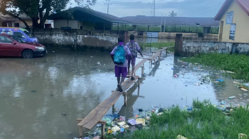 Students walking over flooded areas in Lagos